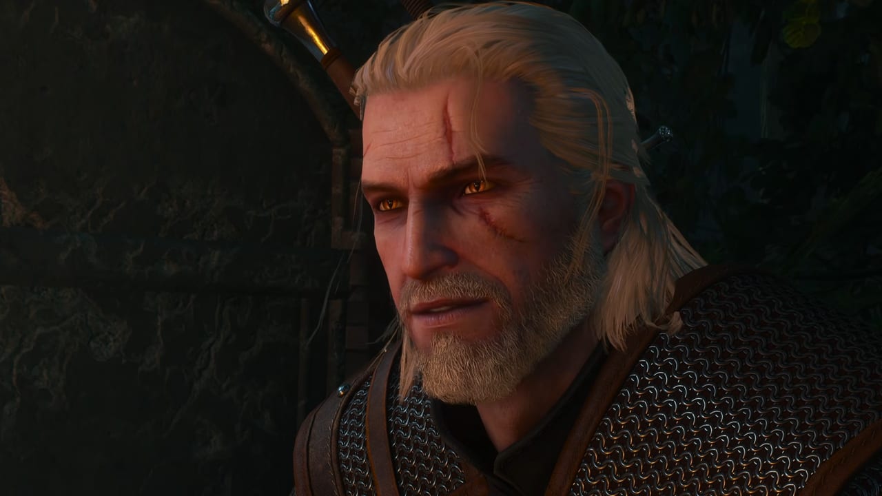 Close-up of Geralt of Rivia in The Witcher 3: Wild Hunt — Remastered, white hair, amber eyes, and chainmail in warm torchlight.